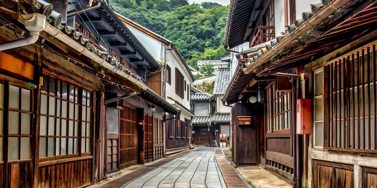 奥へと続く石畳の通りと、両側に歴史ある瓦屋根の古い木造家屋が並ぶ伝統的な町並みの風景
